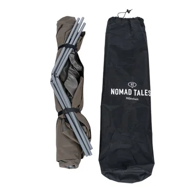 Opgevouwen bruine constructie met metalen stangen en zwarte draagtas met opschrift 'Nomad Tales München'.