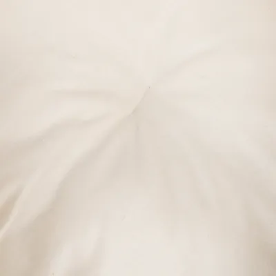 Nahaufnahme eines beigen Stoffbezugs mit leichter Faltenbildung in der Mitte.