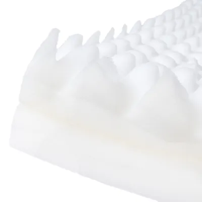 Nahaufnahme einer weissen Schaumstoffmatte mit spitzen, wellenförmigen Erhebungen.