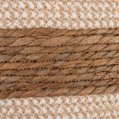 Gros plan sur un tressage de fibres naturelles et blanches, alternant des bandes en paille et en corde. Matériaux visibles : paille, corde textile.