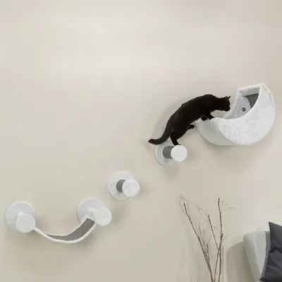 Elemento da arrampicata e riposo da parete per gatti, con più piattaforme e superficie semicircolare. Gatto nero esplora la superficie superiore.