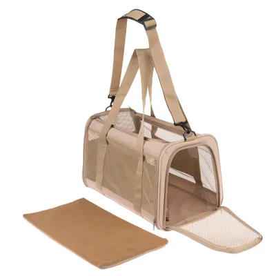 Sac de transport beige en tissu avec panneaux en maille, ouverture zippée à l’avant, deux anses et bandoulière réglable, coussin amovible posé à côté.