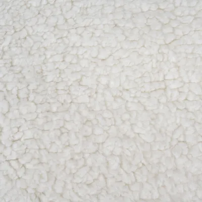 Detailní záběr na bílý, měkký plyšový materiál se strukturovaným povrchem.