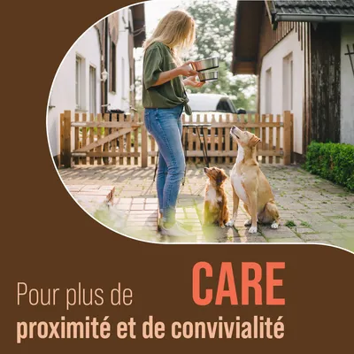 Pour plus de CARE, proximité et convivialité. Texte en français et anglais sur l’image. Femme tenant deux gamelles devant deux chiens assis dans une cour.