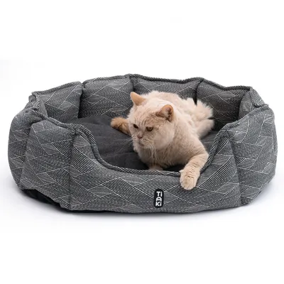 Tiaki лежанка для кошек с серо-черным узором, на которой лежит бежевая кошка.