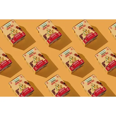 Multiple boxes of grain free chicken recipe pet food displayed in a repeating pattern, highlighting the product's grain free feature and chicken as the main ingredient.