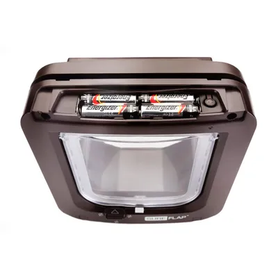 Pet door with battery compartment open, showing four AA batteries inserted at the top of the unit.