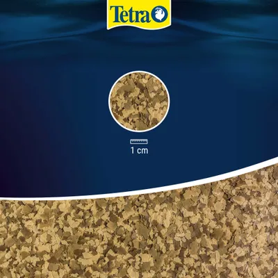 Tetra Flake Food, detailed view of the flakes with scale: 1 cm.