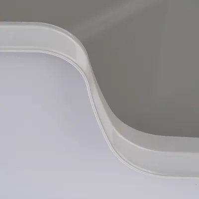 Close-up of a white plastic edge with a curved shape, possibly part of a product.