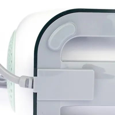 Close-up of a white plastic housing with cable connection and rounded edges. Detailed view of design and material finish.