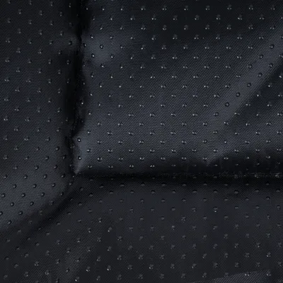 Prim-plan al unui material textil negru, cu puncte și suprafață antiderapantă.