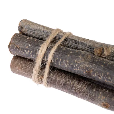 Tre bastoncini di legno scuro legati insieme con una corda naturale.