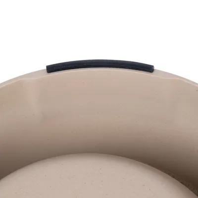 Detailansicht einer beigefarbenen Futterschale mit rutschfestem schwarzen Gummirand.
