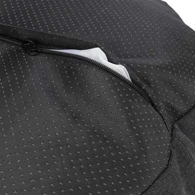 Nahaufnahme eines schwarzen, gepunkteten Stoffbezugs mit Reißverschluss und sichtbarem weißen Innenmaterial.