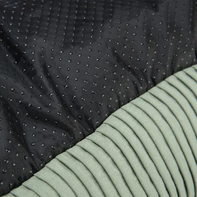 Nahaufnahme eines Materials mit schwarzer, gepunkteter Oberfläche und grünem, geripptem Stoff. Zeigt Texturen für Produktdesign.