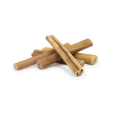 Several rolled-up, brown chew snacks in stick form on a white background.