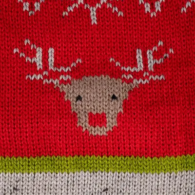 Rotes Strickmuster mit Rentiermotiv, grüner und grauer Streifen am unteren Rand.