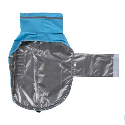 Vue intérieure d’un manteau pour chien bleu avec doublure argentée, fermeture à scratch visible sur le côté droit, matière synthétique brillante.