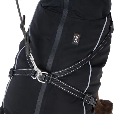 Harnais noir avec surpiqûres réfléchissantes et mousqueton métallique, porté sur un manteau pour chien TIAKI, fermeture éclair visible au centre.
