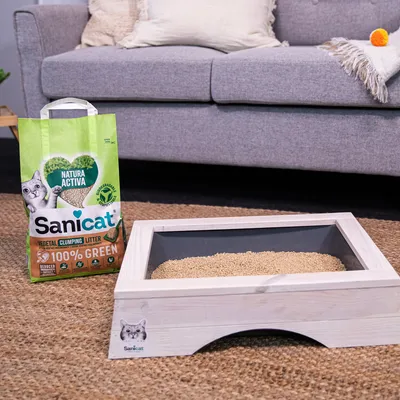 Sanicat Natura Active klontvormende kattenbakvulling, 100% biologisch afbreekbaar, gepresenteerd in houten kattenbak. Verpakking met groen design, kat en milieulogo’s.