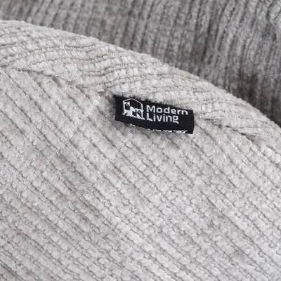 Étiquette avec le texte Modern Living sur tissu beige à texture côtelée, marque visible sur le produit.