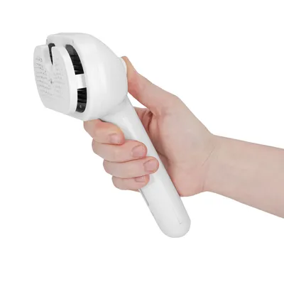 Hand holding a white brush with integrated cleaning system, suitable for removing pet hair.