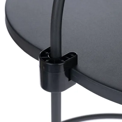 Detailní pohled na černý plastový držák spojující kovovou trubku s kulatou platformou.