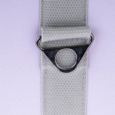 Sangle en tissu gris avec anneau en métal triangulaire, vue rapprochée. Aucun texte ou marque visible.