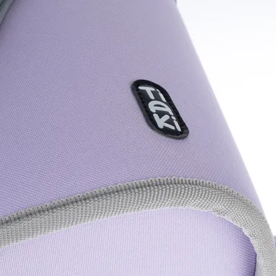 Détail d’un tissu violet avec bordure grise et étiquette visible portant la marque Tiaki.