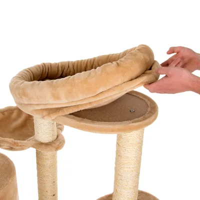 Kattenkrabpaal met sisalpalen en afneembare, beige pluchen ligmand; handen tonen het losmaken van de mand van het plateau.