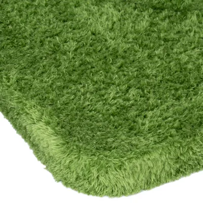 Zelený, nadýchaný povrch obdĺžnikového koberca alebo vankúša. Detailný pohľad na textúru.