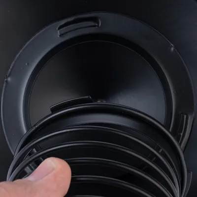 Black, stackable feeding bowl made of plastic with removable insert, close-up.
