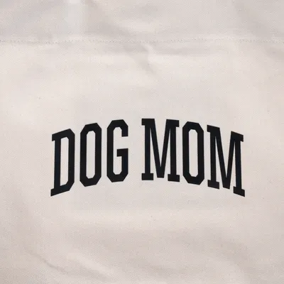 Inscripción "DOG MOM" sobre tela beige.