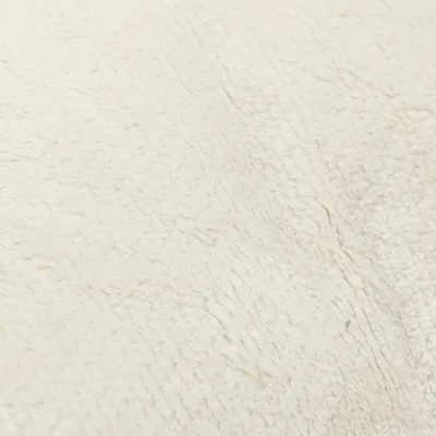 Zbliżenie na kremowy, miękki pluszowy materiał.