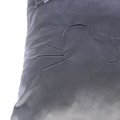 Graues Kissen mit gesticktem Katzengesicht, inklusive Schnurrhaaren und Nase.