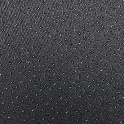 Gros plan sur un tissu noir avec surface antidérapante à picots ronds réguliers, matériau textile visible.