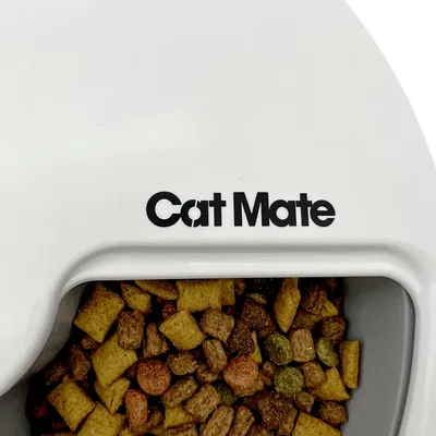 Cat Mate Futterautomat mit Trockenfutter gefüllt, sichtbarer Markenname auf weissem Gehäuse.