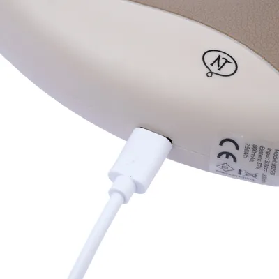 Primo piano di un dispositivo beige con cavo di ricarica USB, marchio CE e dati tecnici: modello 930255, batteria 800mAh, Made in China.