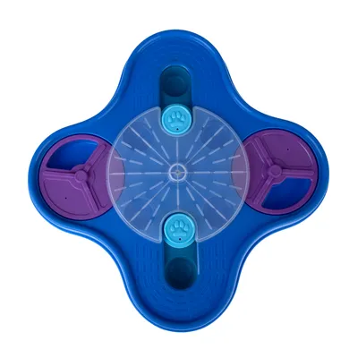 Jouet interactif pour animaux en plastique bleu et violet, avec couvercle transparent central, deux boutons bleus à motif patte et compartiments rotatifs visibles.