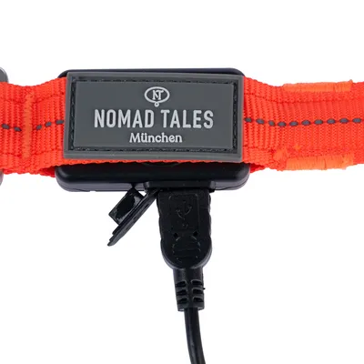 Nomad Tales München narancssárga kutyanyakörv USB-csatlakozóval. A logó és a kábelcsatlakozó részlete.