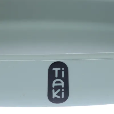 Logo Tiaki pe un produs verde deschis.