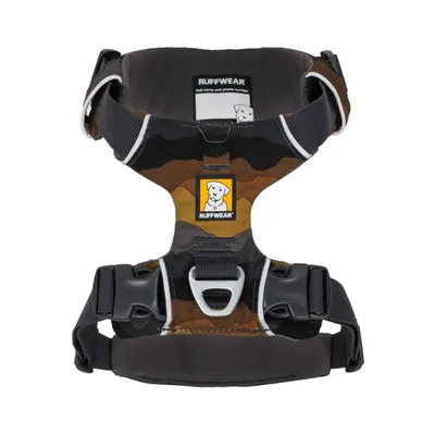 Ruffwear Hundegeschirr mit Camouflage-Design, robusten Schnallen und Metallring für Leinenbefestigung. Sichtbare Markenlogos und Beschriftung: 'trail name and phone number'.
