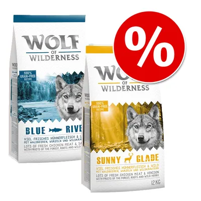 Dvě balení Wolf of Wilderness, varianty Blue River a Sunny Glade, 12 kg, označení 100% grain-free recipe, velká červená ikona procenta pro zvýhodněnou nabídku.
