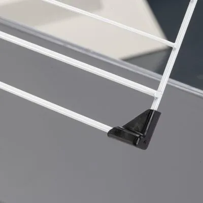 Dettaglio di una griglia in metallo bianco con angolo in plastica nera, vista ravvicinata su fondo grigio.