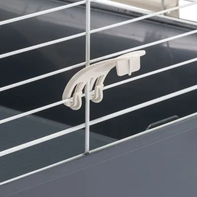 Gancio in plastica bianca fissato su una gabbia con sbarre metalliche bianche e base in plastica grigia, dettaglio del sistema di chiusura o blocco.