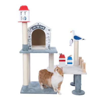 Arbre à chat avec niche décorée 'Love this home', poteaux en sisal, accessoires en bois colorés et figurine de mouette, chat roux et blanc debout devant la structure.