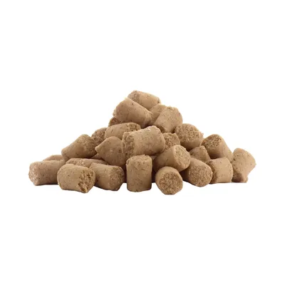 Haufen von beige-braunen, zylinderförmigen Leckerlis oder Snacks für Haustiere.