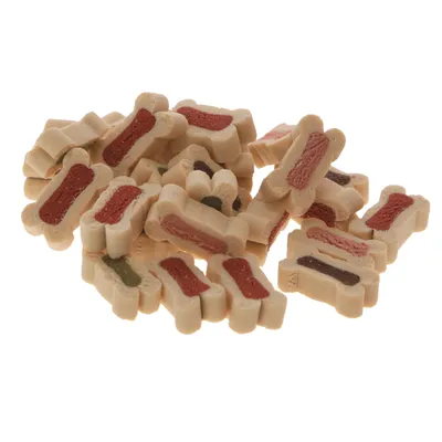 Friandises en forme d’os bicolores, extérieur beige et centre coloré (rouge, vert, marron), empilées en vrac. Aucun emballage ou marque visible.