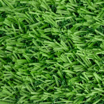 Close-up of artificial green grass carpet with detailed structure of plastic fibres.