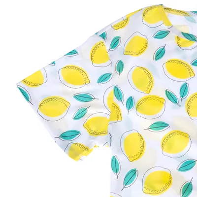 T-shirt à manches courtes avec motif de citrons jaunes et feuilles vertes sur fond blanc, tissu lisse visible.